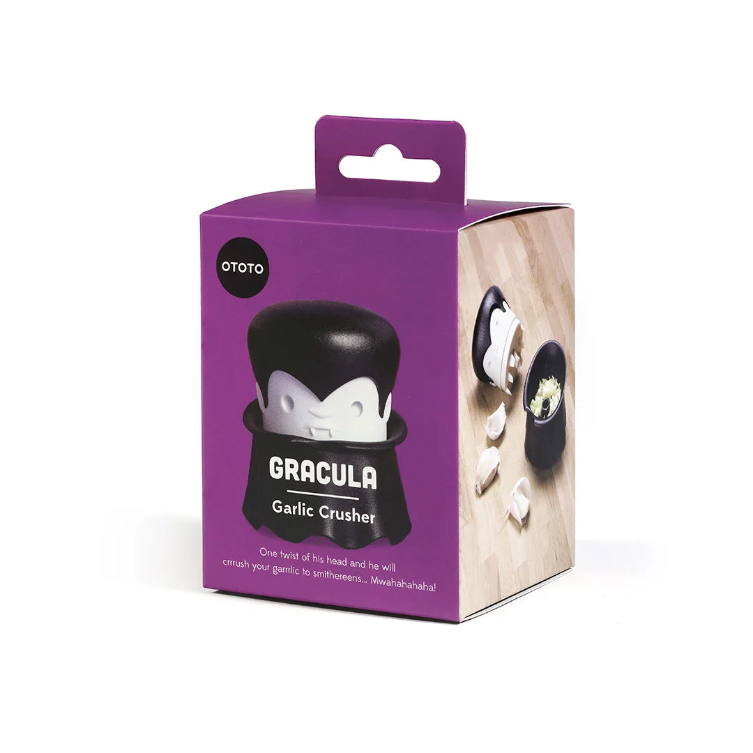 The Gracula crusher by OTOTO has a vampire motif, packaged with cloves on a wooden background.