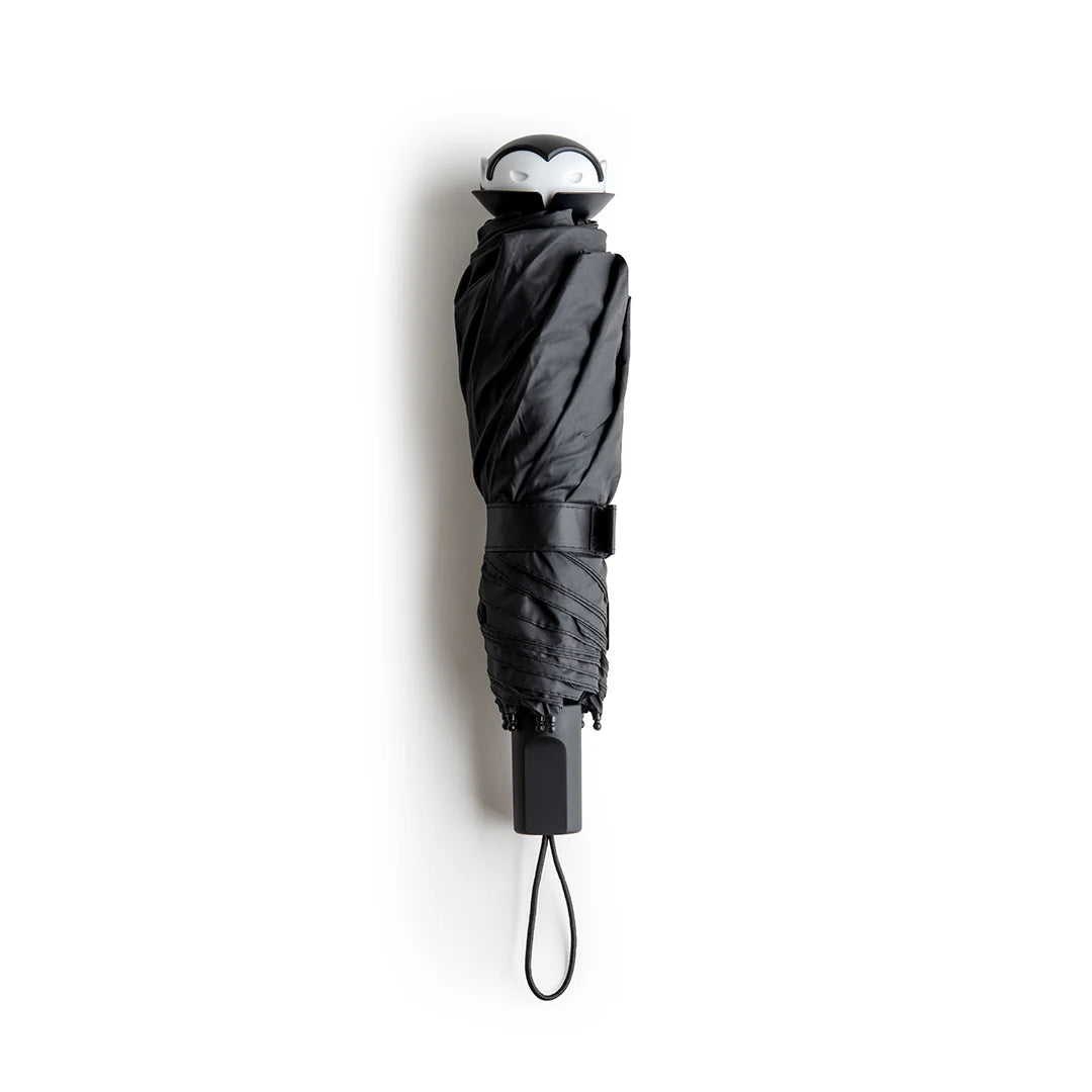 Stylish Spookula umbrella by OTOTO, features a penguin handle and wrist strap, on a white background.